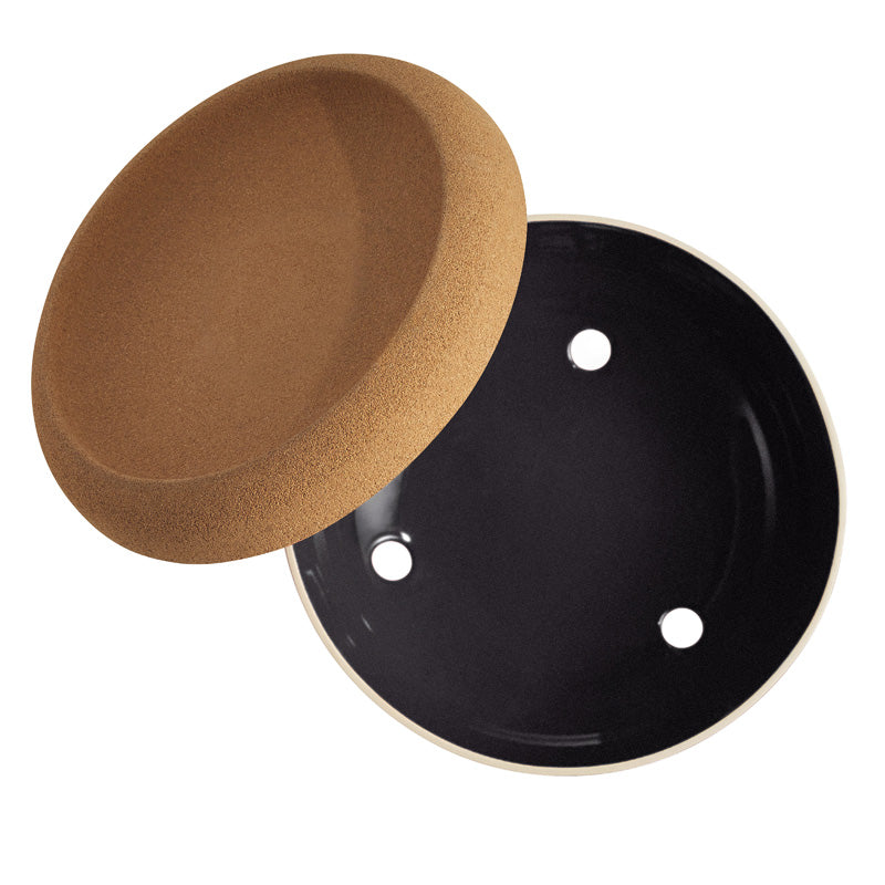 Sicht von oben auf die Belüftungslöcher der Emile Henry – Große Aufbewahrungsschale mit Korkdeckel – Schwarz, Durchmesser 36 cm im Home-and-Kitchen Online Shop