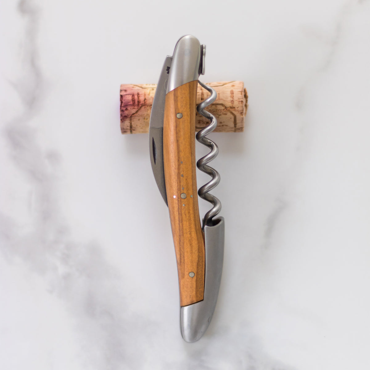 Formschön und elegant: Forge de Laguiole-Sommeliermesser mit Griff aus Olivenholz inkl. Kapselschneider, handgefertigte Edelstahlklinge, eingebauter Korkenzieher mit 5 Windungen.
