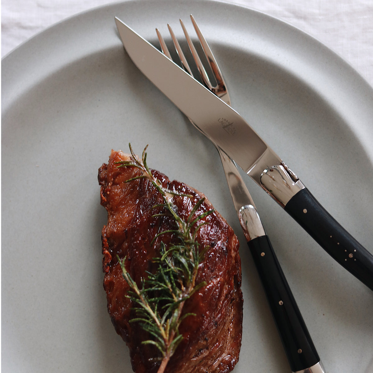 2er Set Tafelmesser von Forge de Laguiolel, auch geeignet als Steakmesser, mit handgeschnitzten Griffen aus schwarzem Naturhorn vom Aubrac-Rind. 
Online-Shop Home-and-Kitchen.de