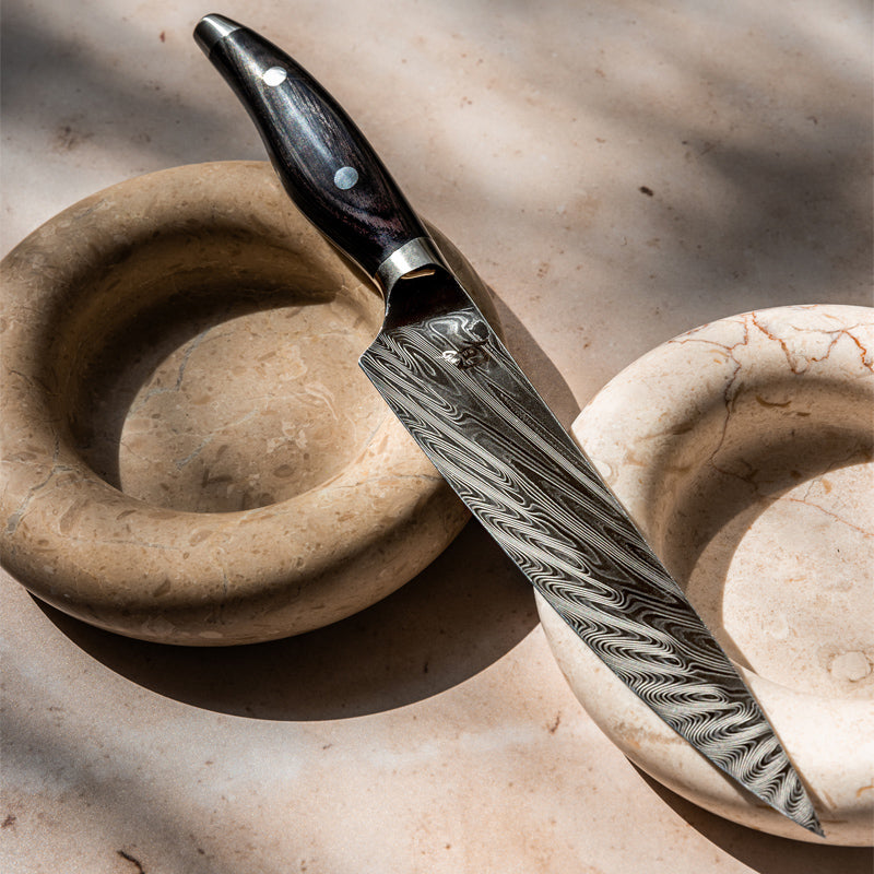 Typisch, strahlenförmiges Damastmuster auf den Klingen der Messer von KAI, beidseitig geschliffen, handgefertigt in Japan 
Online-Shop Home-and-Kitchen.de