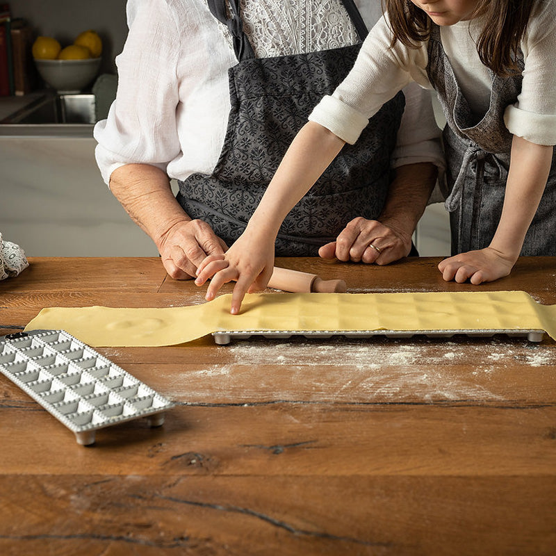 Im Handumdrehen gemacht: 48 quadratische Ravioli mit einem Durchmesser von 25x25 mm, in der Ravioli-Form von Marcato, aus Aluminium, Gummifüsse verhindern das Verrutschen, Holz-Teigroller im Lieferumfang enthalten, in Geschenkbox 