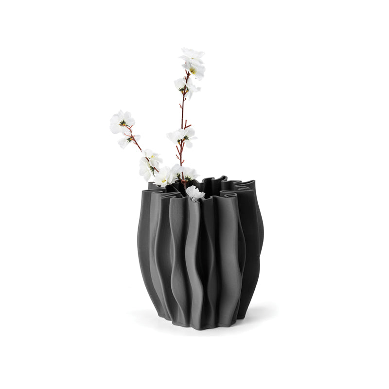 Die Keramik-Vase SERENEE von Philippi Design ist ein Unikat und fällt besonders durch ein dezentes Streifenmuster auf, welches durch ein 3D-Druckverfahren entsteht. Sie ist in einem matten Grau gehalten, hat eine Höhe und einen Durchmesser von 22 cm. Im Inneren der Vase befindet sich bis zu halber Höhe eine Glasur, damit auch frische Blumen in ihr zur Geltung kommen.