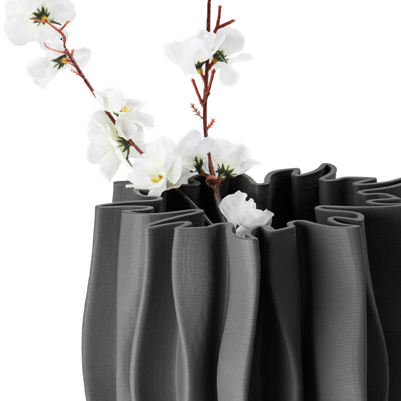 Die Keramik-Vase SERENEE von Philippi Design ist ein Unikat. Sie ist in einem matten Grau gehalten, hat eine Höhe und einen Durchmesser von 22 cm. Im Inneren der Vase befindet sich bis zu halber Höhe eine Glasur, damit auch frische Blumen in ihr zur Geltung kommen. Durch das spezielle 3D-Druckverfahren entsteht ein dezentes ansprechendes Rillenmuster aus Keramik.