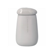 Die Räder Design Steingut-Vase "Wachse über dich hinaus", wurde in Kieselstein-Form gestaltet und auf der matten Außenseite mit dem Schriftzug versehen. Ihr Inneres ist glasiert und ebenso der Deckel, der ein kleines Loch für einzelne Blumenstängel hat. Ihre Größe beträgt 10,3x8,4x17,4 cm.