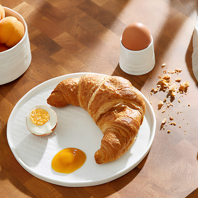 Guten Appetit! Zu deinem Frühstücksei passt der Eierbecher aus Porzellan aus der Serie "Raumpoesie" . Er hat außen einen Schriftzug in Weiß und ist innen glasiert. Seine Höhe beträgt 5 cm, sein Durchmesser  5,5 cm.