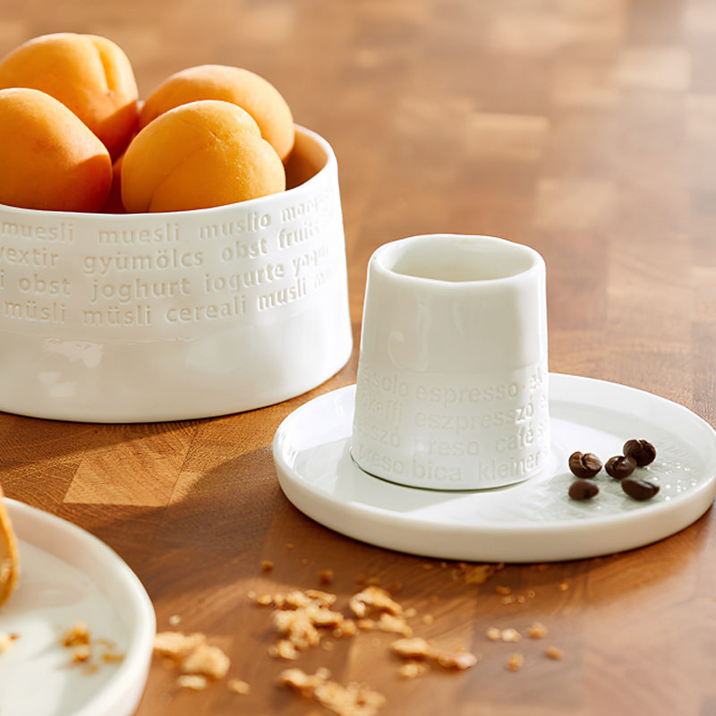 Ein stylischer Platz für dein Frühstücksei - der Eierbecher  FRÜHSTÜCK aus Porzellan aus der Serie "Raumpoesie" hat außen einen Schriftzug in Weiß und ist innen glasiert. Seine Höhe beträgt 5 cm, sein Durchmesser  5,5 cm.