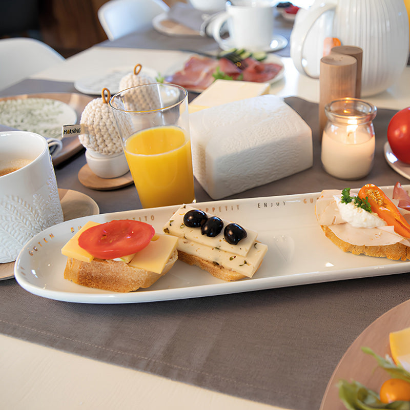 "Guten Appetit" in mehreren Sprachen, ziert die Servierplatte von Räder Design am oberen Rand. Mit ihrer Länge von 40 cm, einer Breite von 10 cm und einer Höhe von 2,3 cm, bietet sie für viele Leckereien Platz. 
