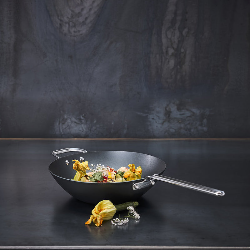 Der BLACK IRON Wok von Scanpan ist PFAS-frei,  hat einen hohen Rand  und einen Stielgriff aus hitzebeständigem Edelstahl. Der 2. Griff ist  angenietet. 
Online-Shop Home-and-Kitchen.de