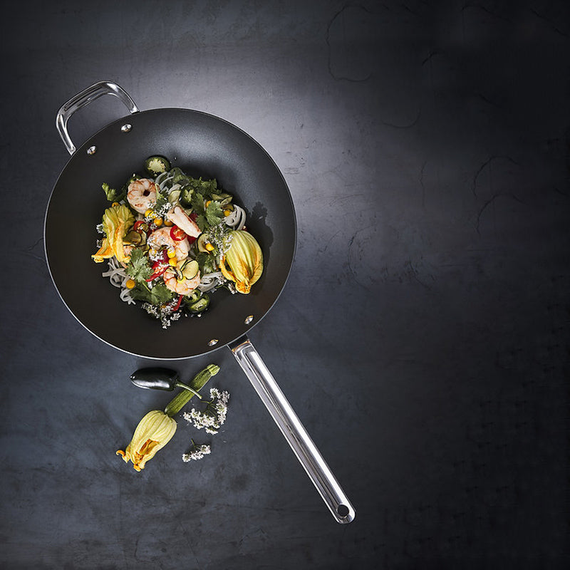 BLACK IRON Wok von Scanpan hat einen hohen Rand  und einen Stielgriff aus hitzebeständigem Edelstahl. Der 2. Griff ist  angenietet. 