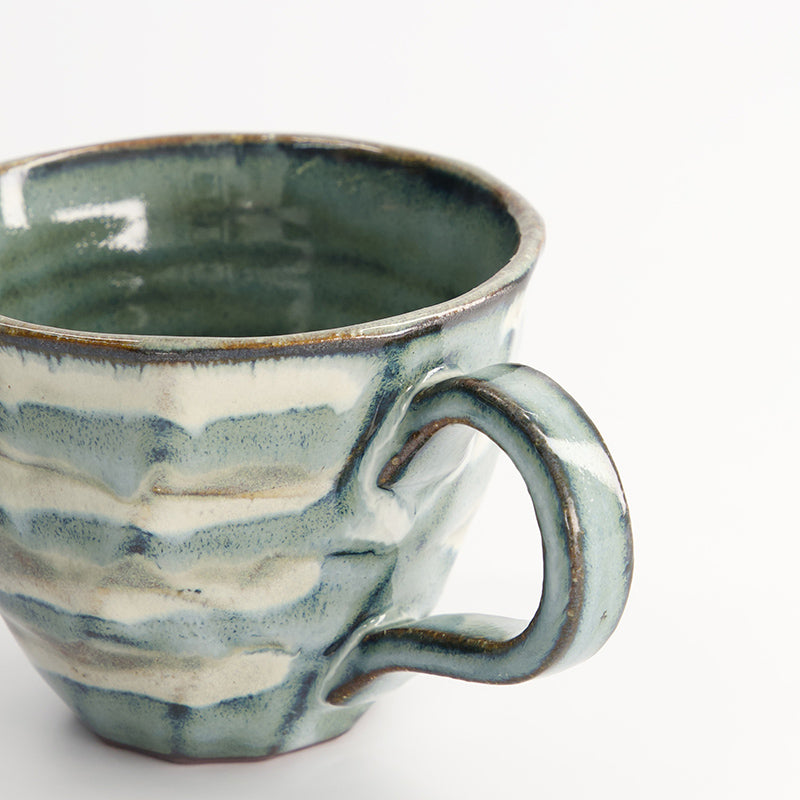 Beige-grüne Henkeltasse von Tokyo Design, Porzellan, fühlbares Relief mit ineinanderfliessenden Streifen in weiß und grün. Höhe 9,5 cm / Ø 7,5 cm (Breite mit Henkel: 12,5 cm) , Volumen 200 ml